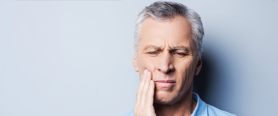 man holding his jaw in pain